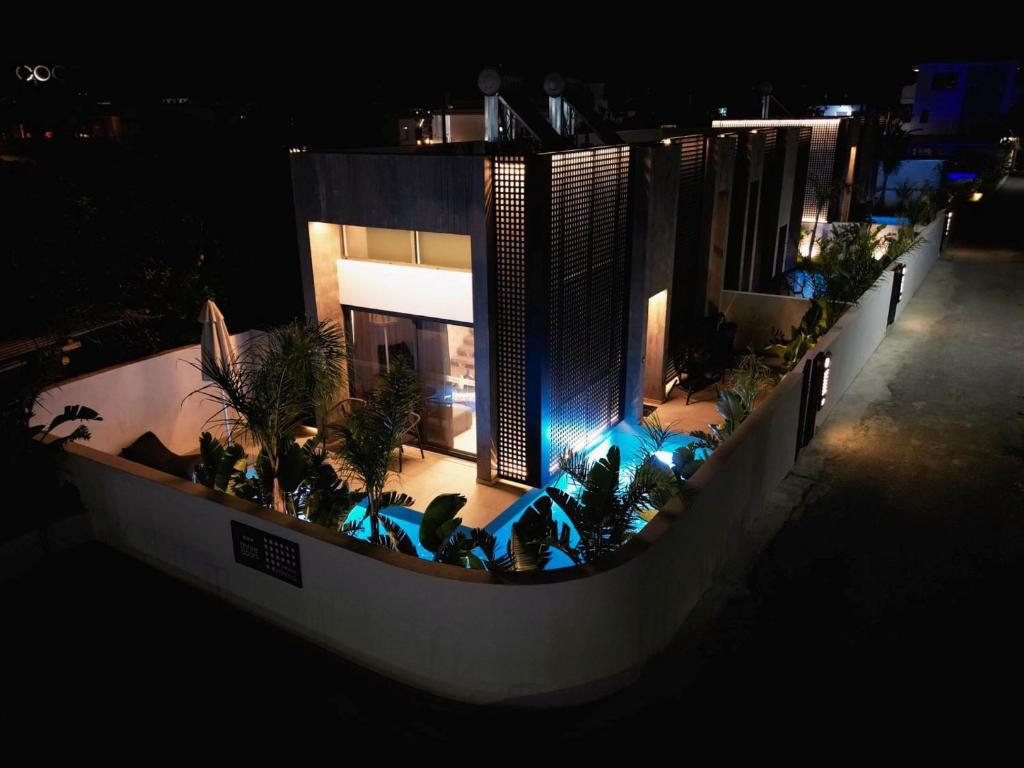 a night view of a house with a pool and plants at Three Doors Villa Complex-Faliraki in Faliraki