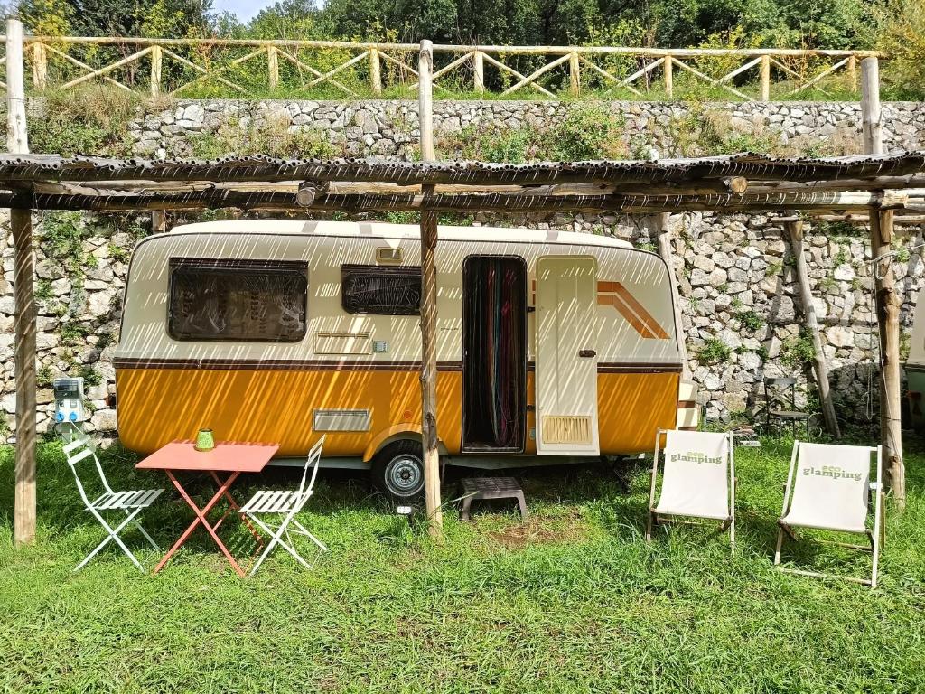 an rv parked under a stone wall at Ecoglamping Tramonti in Tramonti