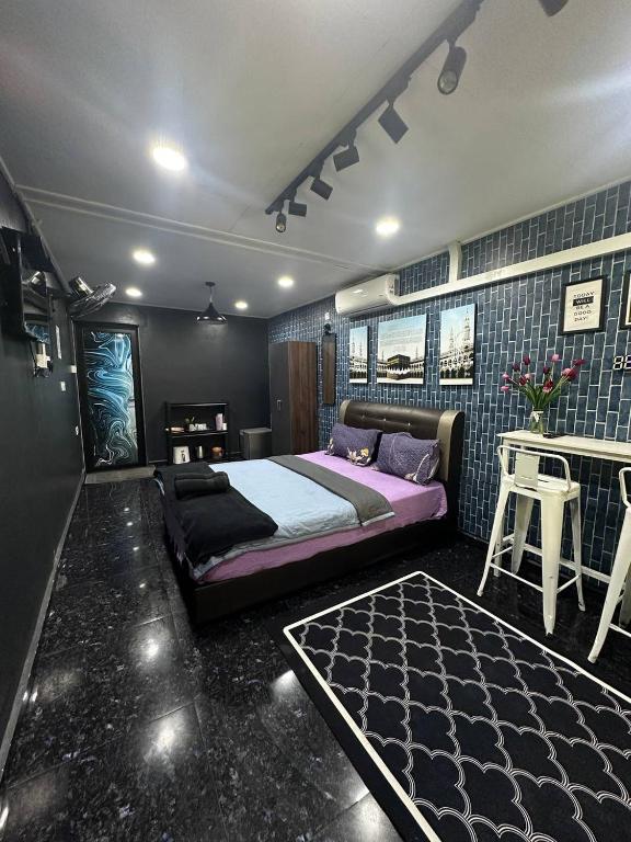 a bedroom with a large bed and a table and a tableablish at Studio D'Makmur in Mersing