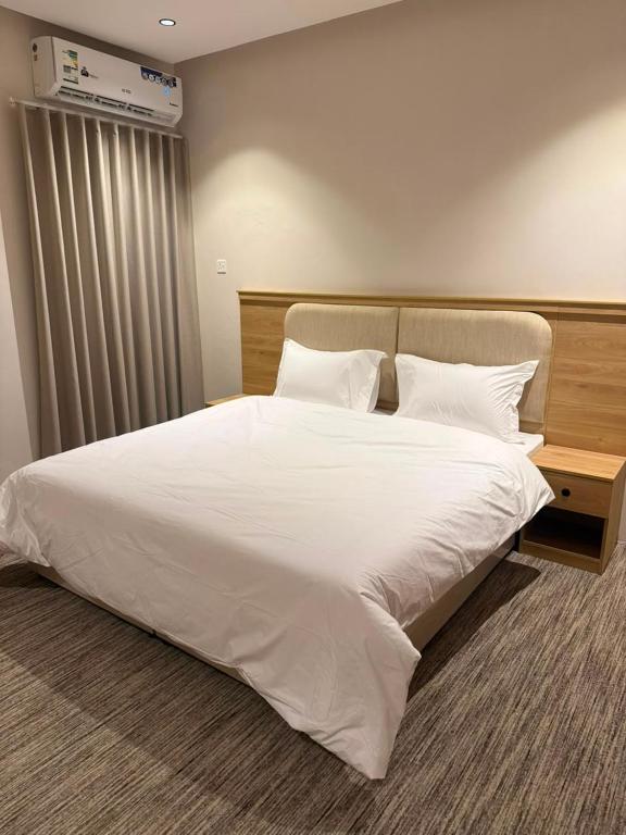 a bedroom with a large bed with white sheets and pillows at فيو بارك للاجنحة الفندقية in Al Kharj