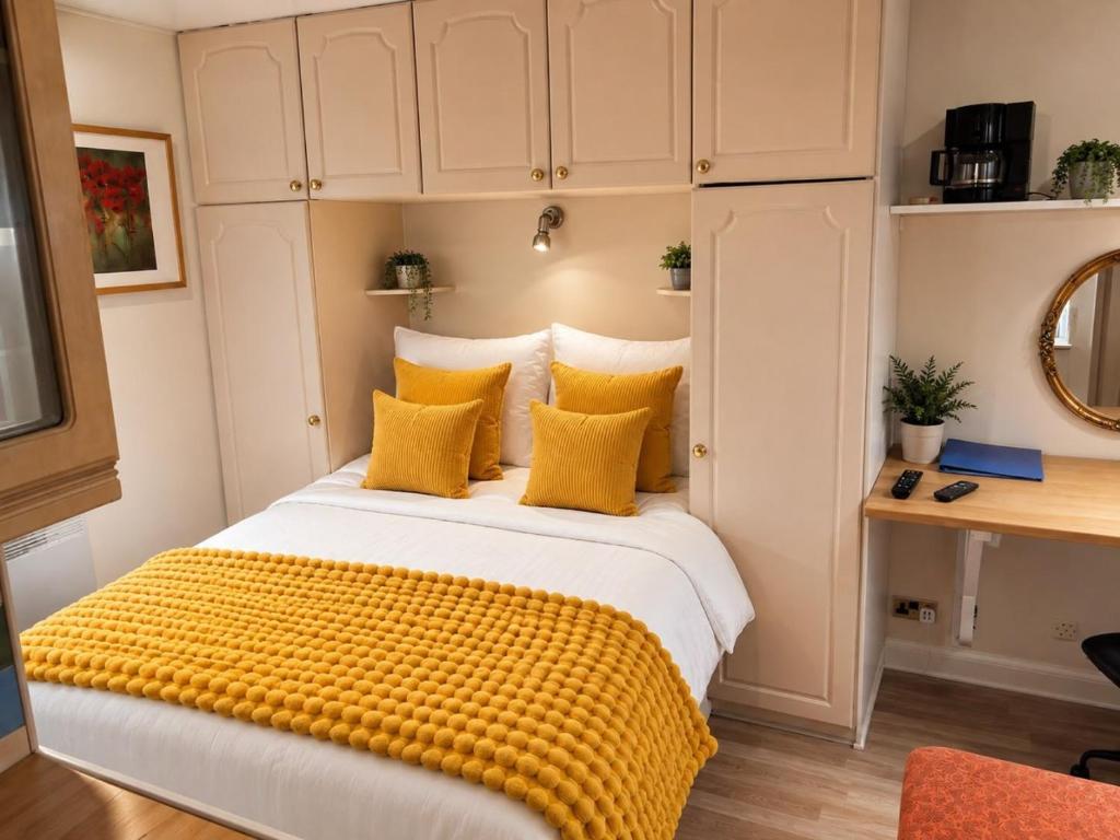 a bedroom with a large bed with yellow pillows at Harman Suites 1 & 2 in Leeds