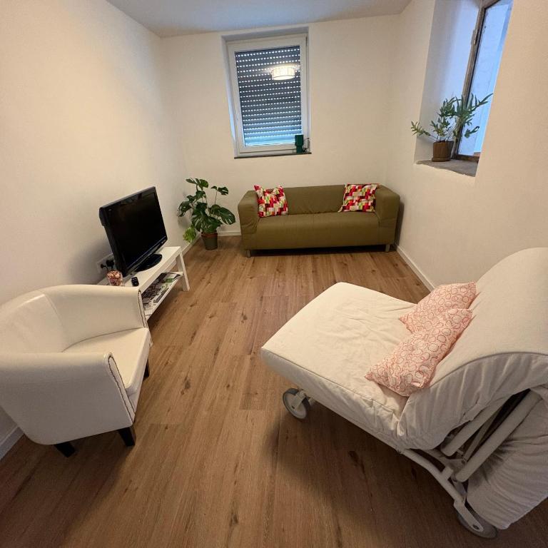 a room with a bed and a chair and a couch at TourBase Dahlem in Dahlem