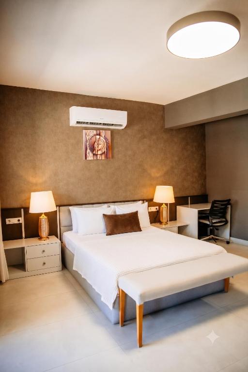 a bedroom with a large white bed and two lamps at Guney House by Villa Safiya in Fethiye