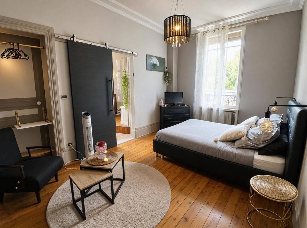 a bedroom with a bed and a living room at Gîte du Pré Nattier - Gisors centre in Gisors