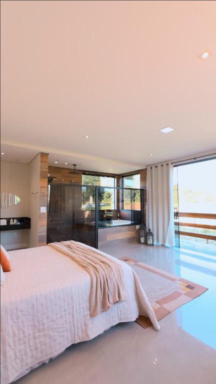 a bedroom with a large bed and a pool at Chalé Refúgio Fegama in Passa Quatro