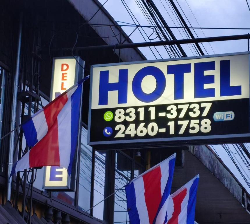 a hotel sign with flags in front of a building at Hospedaje del norte in Quesada