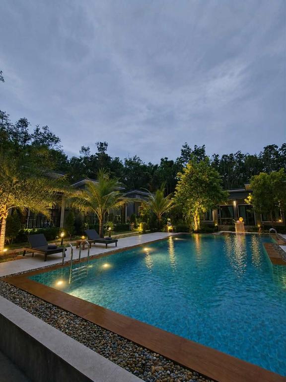 a large swimming pool with lights in a resort at The Cushty Days Lanta in Ko Lanta