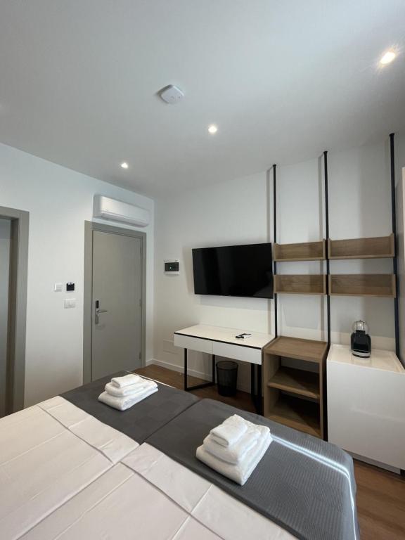 a room with a bed and a desk and a television at Eden Center Rooms in Durrës