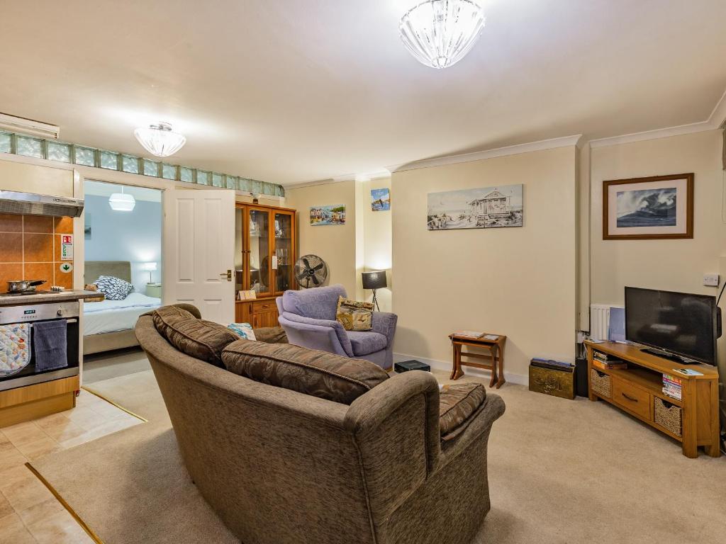 a living room with a couch and a television at The Garden Flat in Torquay
