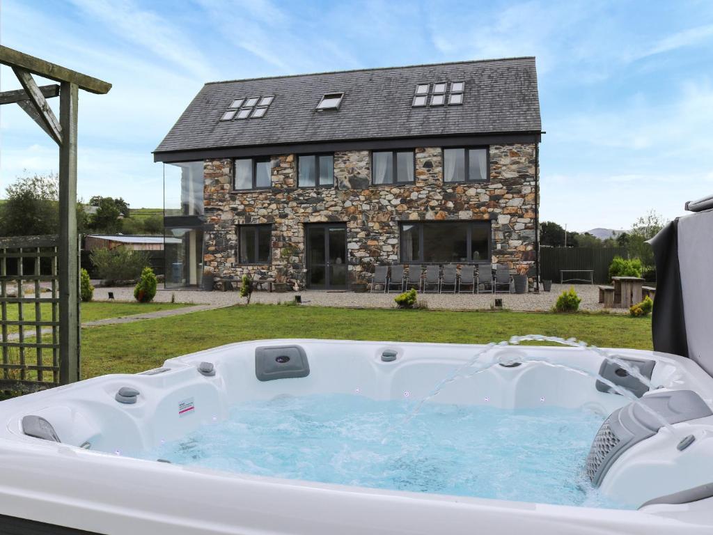 a hot tub in front of a house at Snowdon Summit View in Llanllyfni