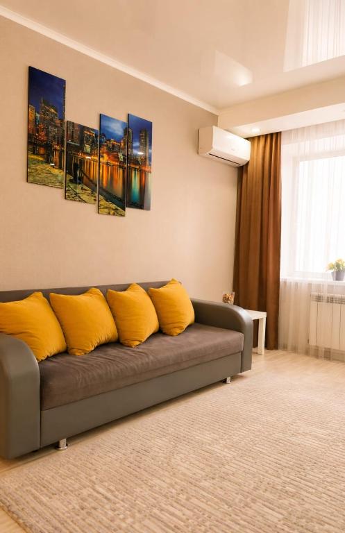 a living room with a couch with yellow pillows at Кошкарбаева 58 in Kokshetau