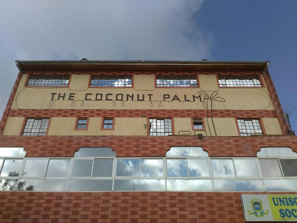 un edificio con un cartel en el costado en The Coconut Palm Hotel, en Ndaragwa