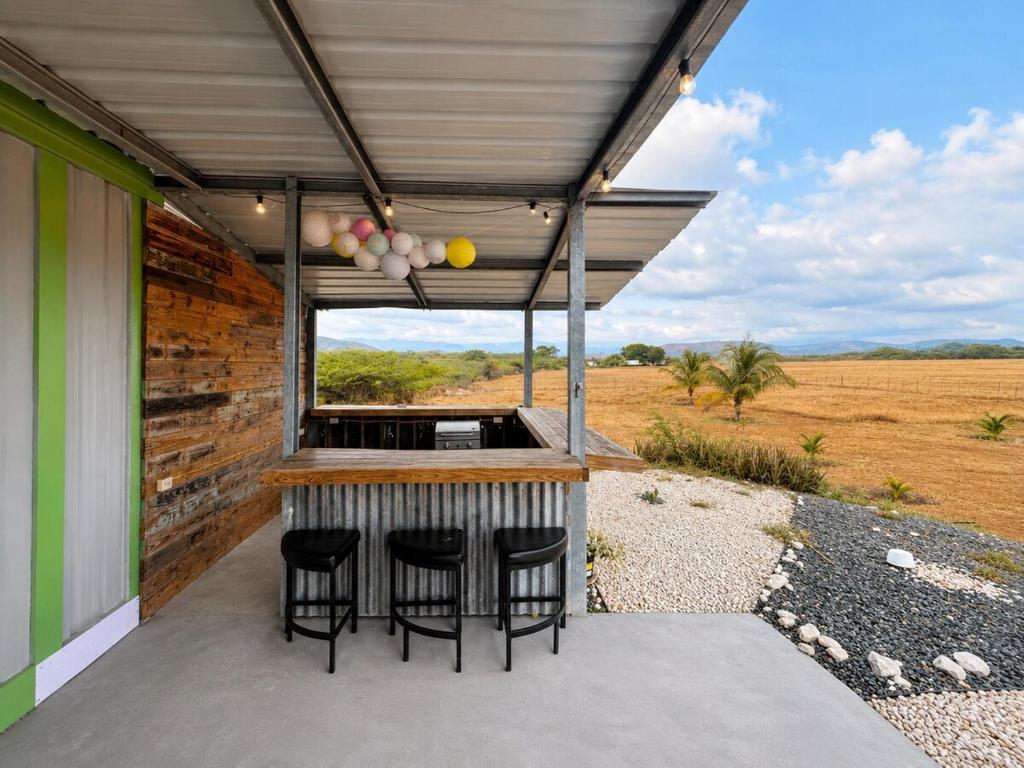 a bar on the back of a house with stools at Finca Sol y Sal 