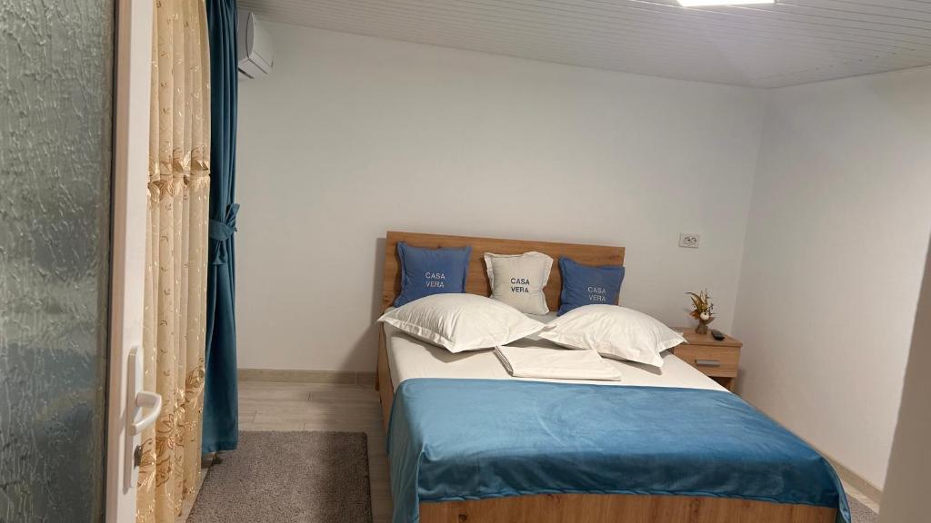 a bedroom with a bed with blue and white pillows at Casa Vera in Corbu