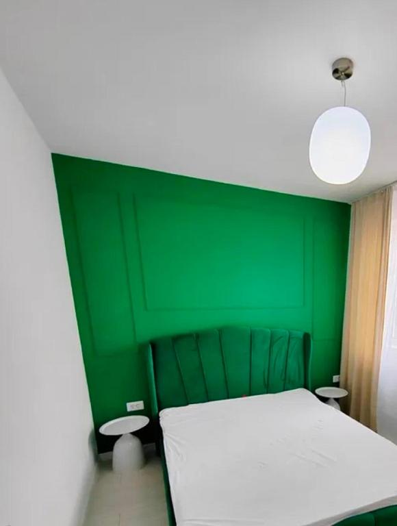 a green bedroom with a bed and a green wall at Exclusive location in West Bay