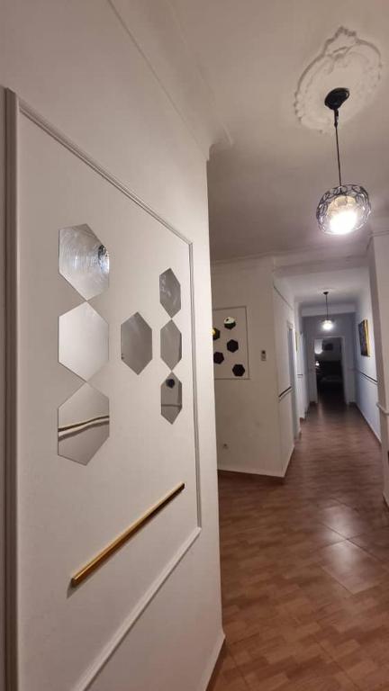 a hallway with a white wall with art on it at F3 de luxueux in Bejaïa