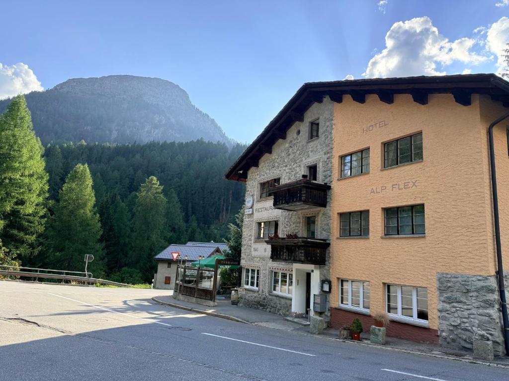 a building on the side of a road next to a mountain at Hotel Alp Sur in Mühlen