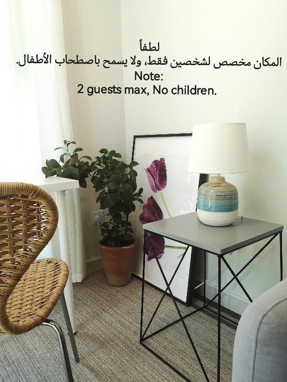 a table with a lamp on it next to a chair at Little Garden private pool villa in Al Ḩamrāʼ