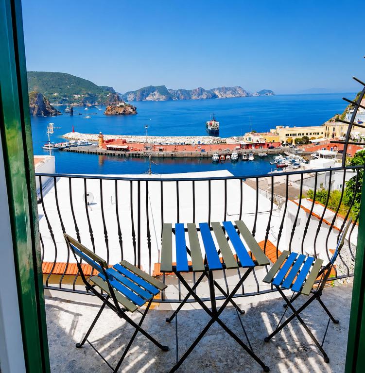 a balcony with two chairs and a view of a harbor at Maridea - Camere con vista al Porto in Ponza