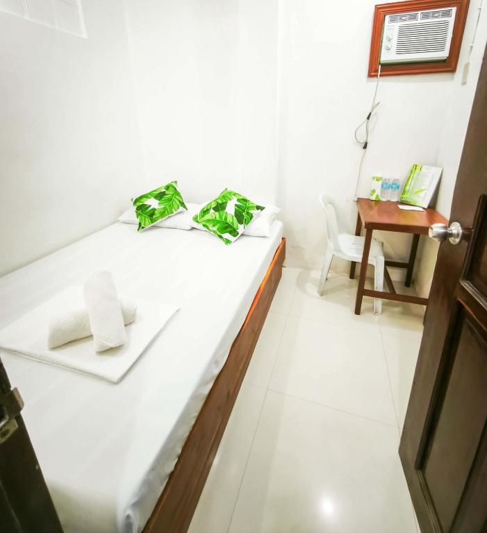 a room with a bed with a chair and a desk at Joyful Guest House in El Nido