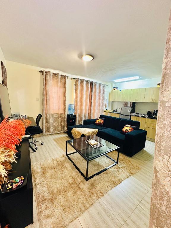 a living room with a couch and a table at Stylish Ngong Retreat with Balcony & Rooftop Lounge The Moon Stays in Ngong