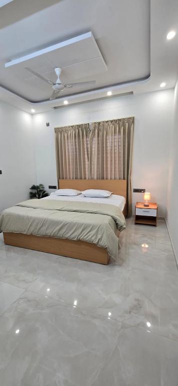 a bedroom with a bed in a white room at Cherry Bloom in Chikmagalūr