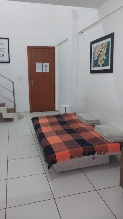 a bedroom with a bed with a checkered blanket at Flat Shopping Amarração N - 129 in Luis Correia