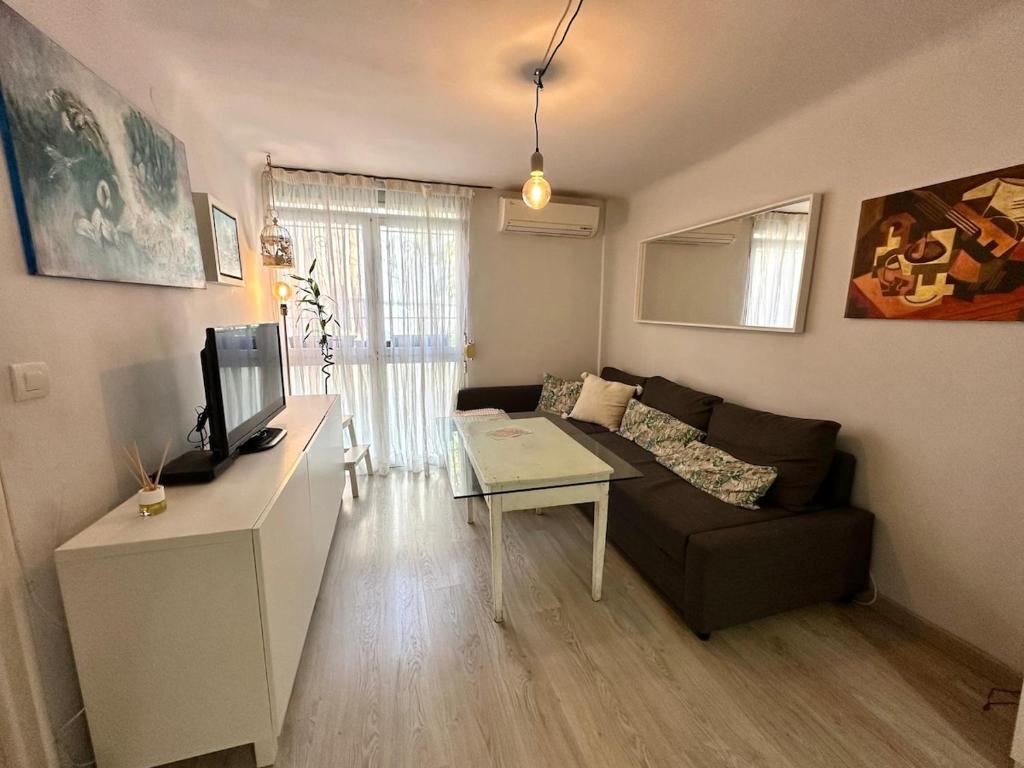 a living room with a couch and a table at Apartamento próximo al palacio de congresos in Granada