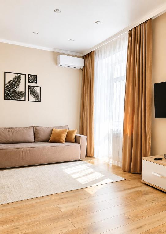 a living room with a couch and a television at Студия ЖК "Кенесары" in Kokshetau