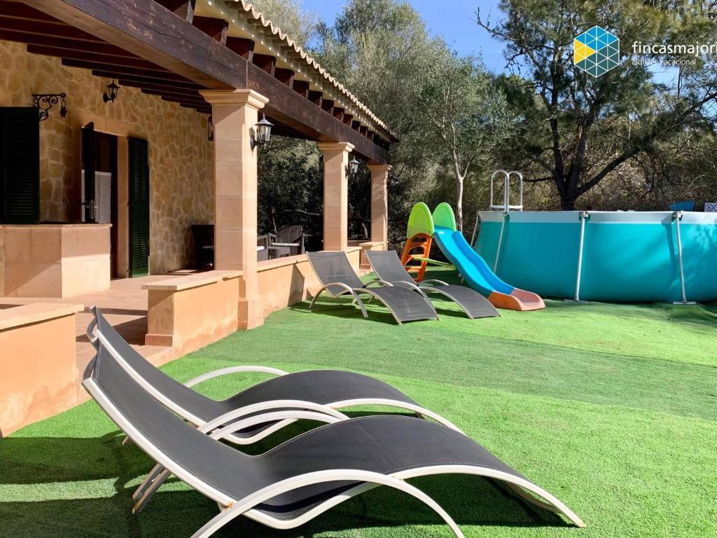 a yard with a playground with chairs and a slide at Cas rellotger country house in Llucmajor