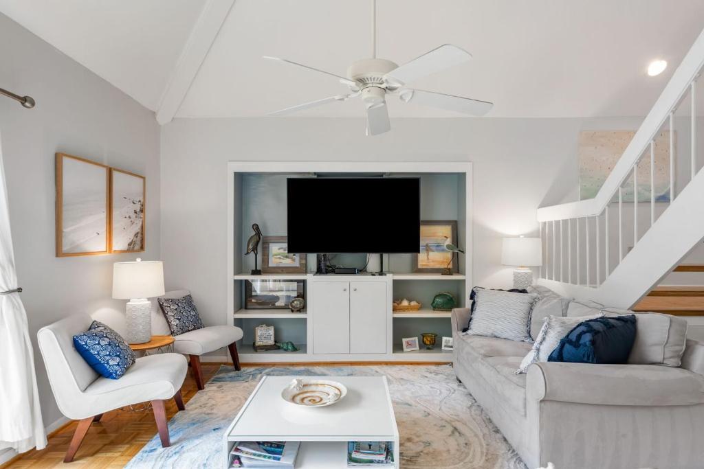 a living room with a couch and a tv at 735 Spinnaker Beach House in Seabrook Island