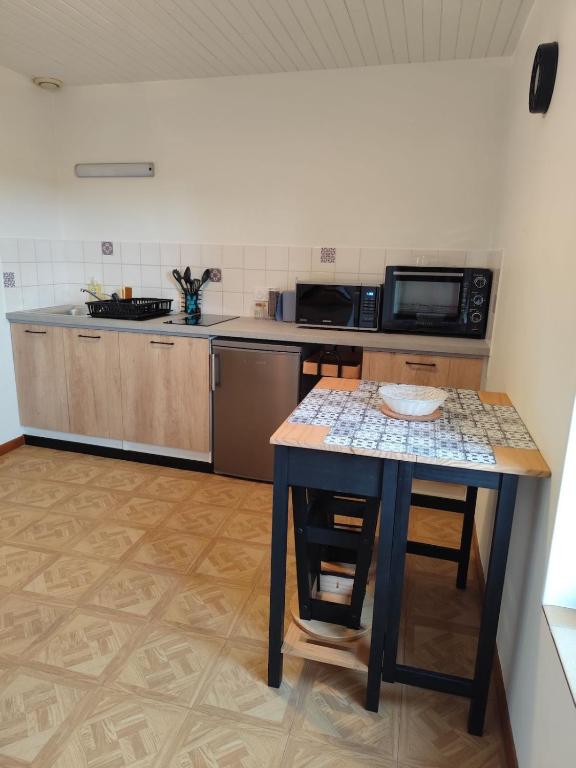 a small kitchen with a table and a microwave at Petite escapade dans le Perche 1 in Sainte-Céronne-lès-Mortagne