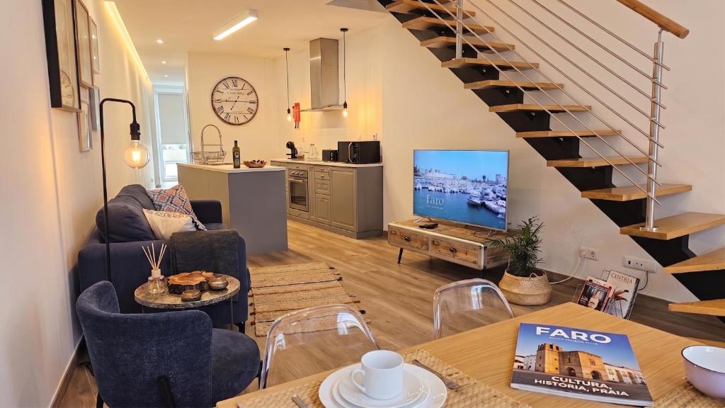 a living room with a couch and a tv and a staircase at Casa da Mouraria in Faro