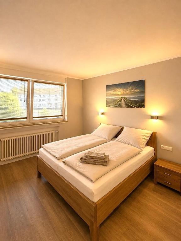 a bedroom with a large bed with two windows at City Event Hotel in Dinslaken