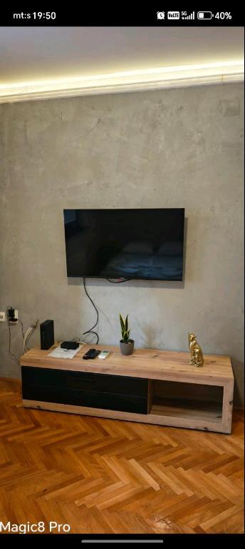 a desk in a room with a tv on a wall at Niški kutak in Niš