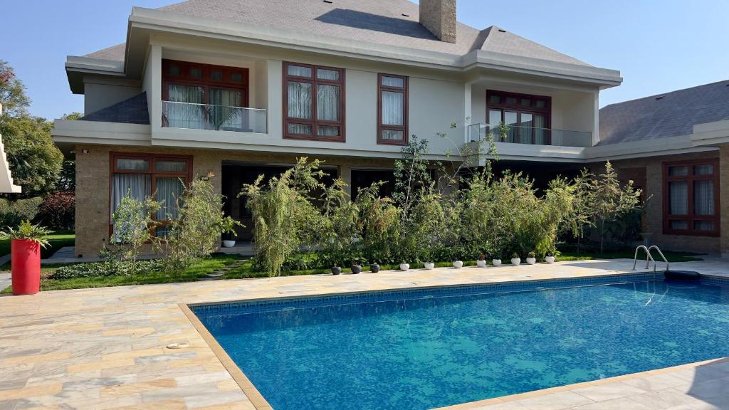 a house with a swimming pool in front of a house at Uyoga House in Arusha