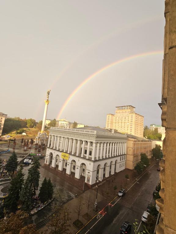 a rainbow over a city with a white building at Кімната в квартире in Kyiv
