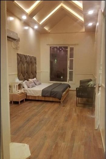 a bedroom with a large bed and a window at Sukoon Farms in Greater Noida