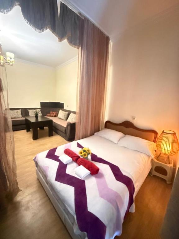 a bedroom with a large bed and a living room at Legacy Rooms in Old Tbilisi FREE parking in Tbilisi City