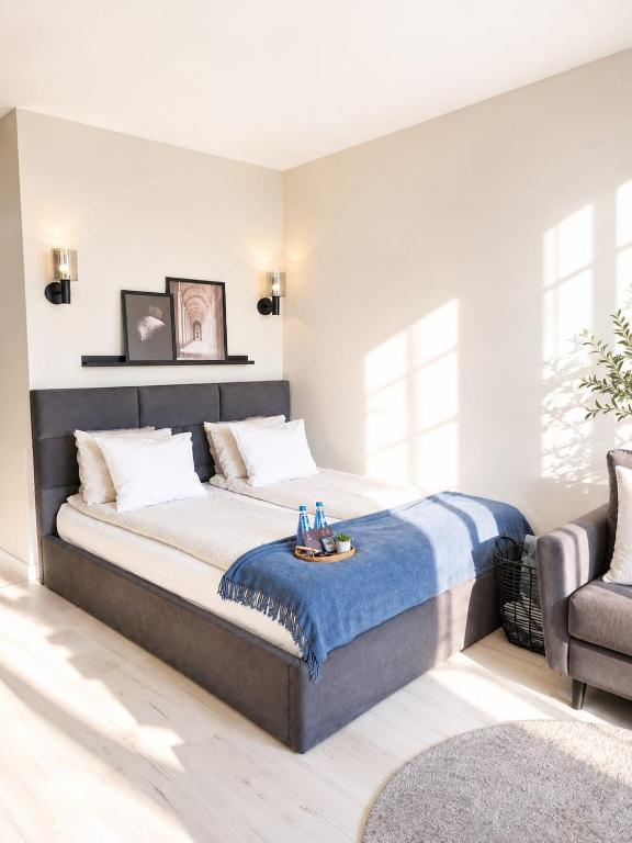 a bedroom with a large bed with a blue blanket on it at Kairos Apartments - Lothus - darmowy garaż podziemny, ścisłe centrum in Gliwice