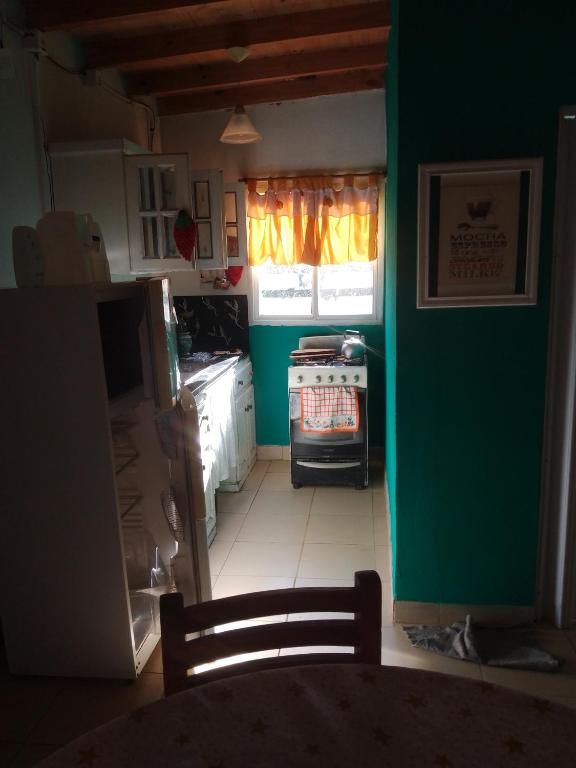 a kitchen with a stove and a green wall at casa en toninas in Las Toninas