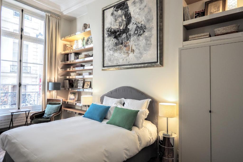 パリにあるリシュリュー シックスイーツのベッドルーム1室(青い枕2つ付きのベッド1台付)