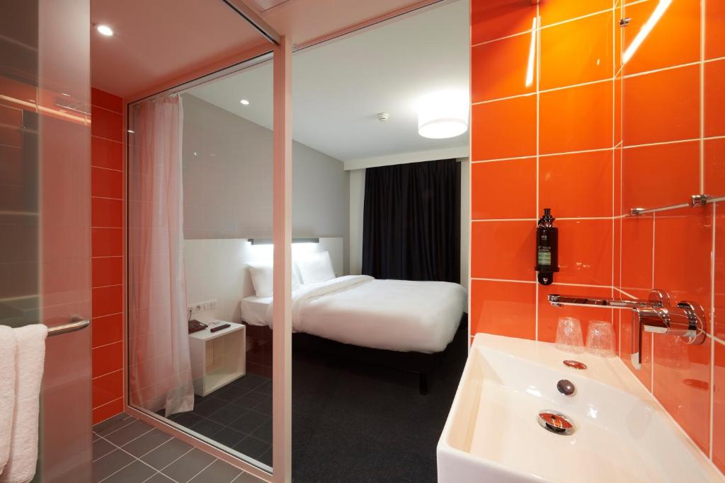a hotel bathroom with a bed and a tub and a sink at Le Nex2 in Tarbes