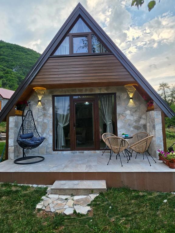 a house with a blue chair and two chairs on a patio at Vila Milena in Žabljak