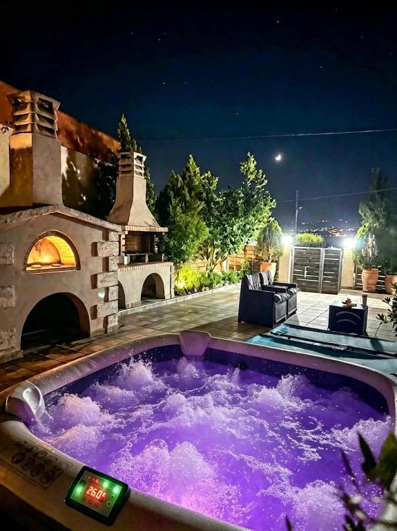 a jacuzzi tub in a backyard at night at Villa Asterousia with Private Night Spa, BBQ & Lounge in Stérnai