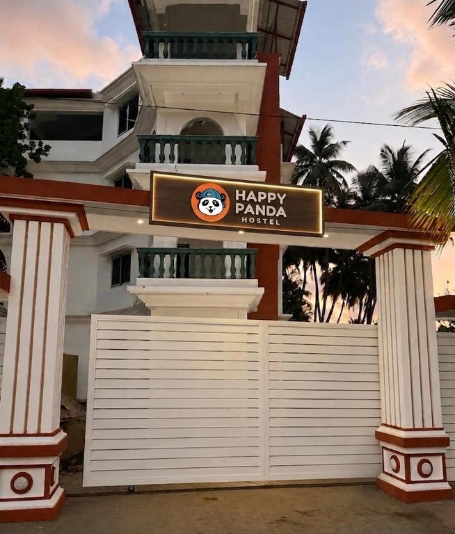 a large white house with a happy rancher sign on it at Happy Panda Hostel Arambol Goa in Arambol