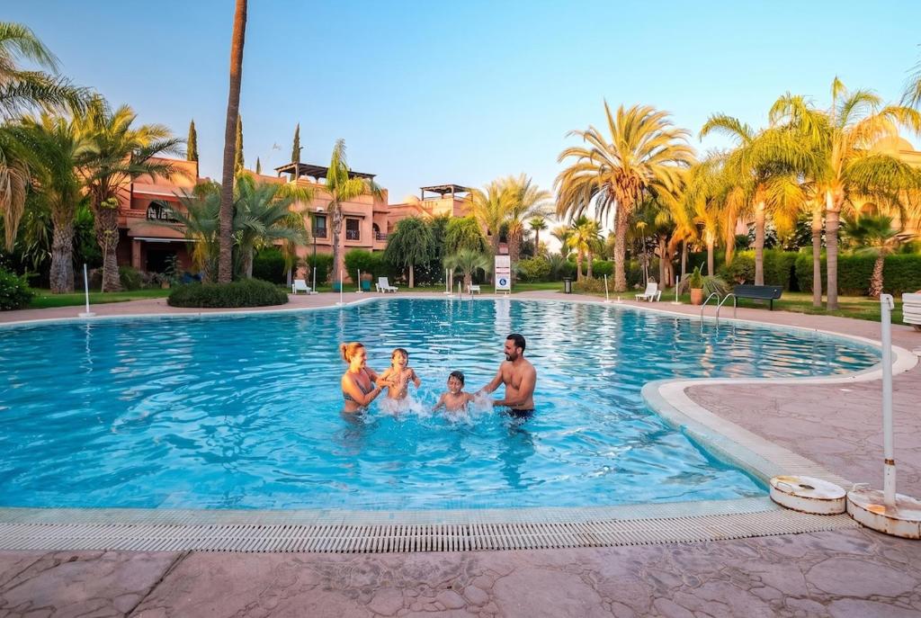 a family in a swimming pool at a resort at Atlas Golf Resort in Marrakesh