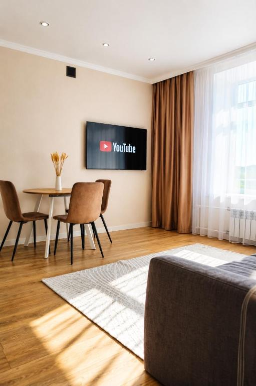a room with a table and a tv on the wall at Жк "AUEZOV" in Kokshetau
