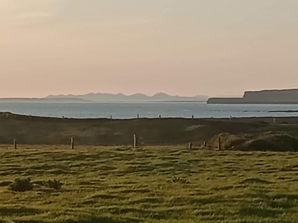a field with the ocean in the background at Mutton House in Milltown Malbay