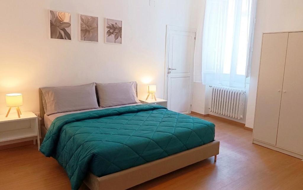 a bedroom with a bed with a green blanket on it at Civico 16 in Sulmona
